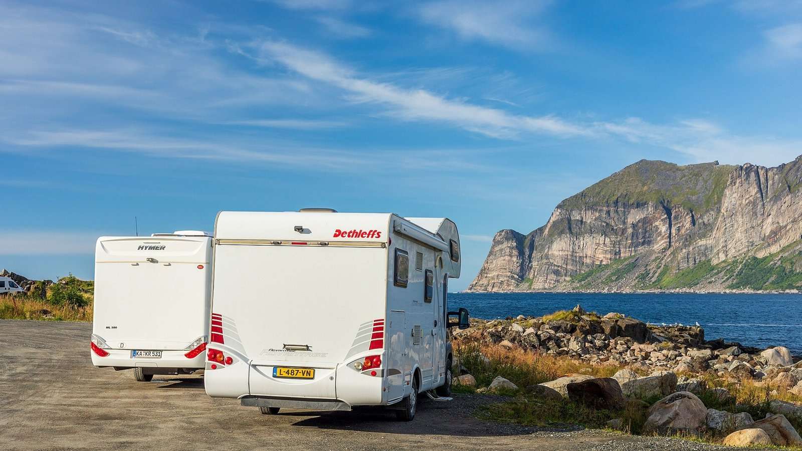 To bobiler parkert ved sjøen i Mefjordvær på Senja